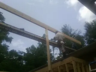 Carpenter setting a ridge beam over a new addition frame — Ice Dam Removal by Roofing Brothers in Plaistow