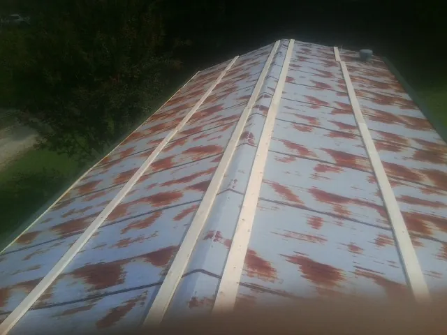 Rusted metal roof panels with new wood purlins before replacement — Storm Damage Roof Repair in Plaistow by Roofing Brothers