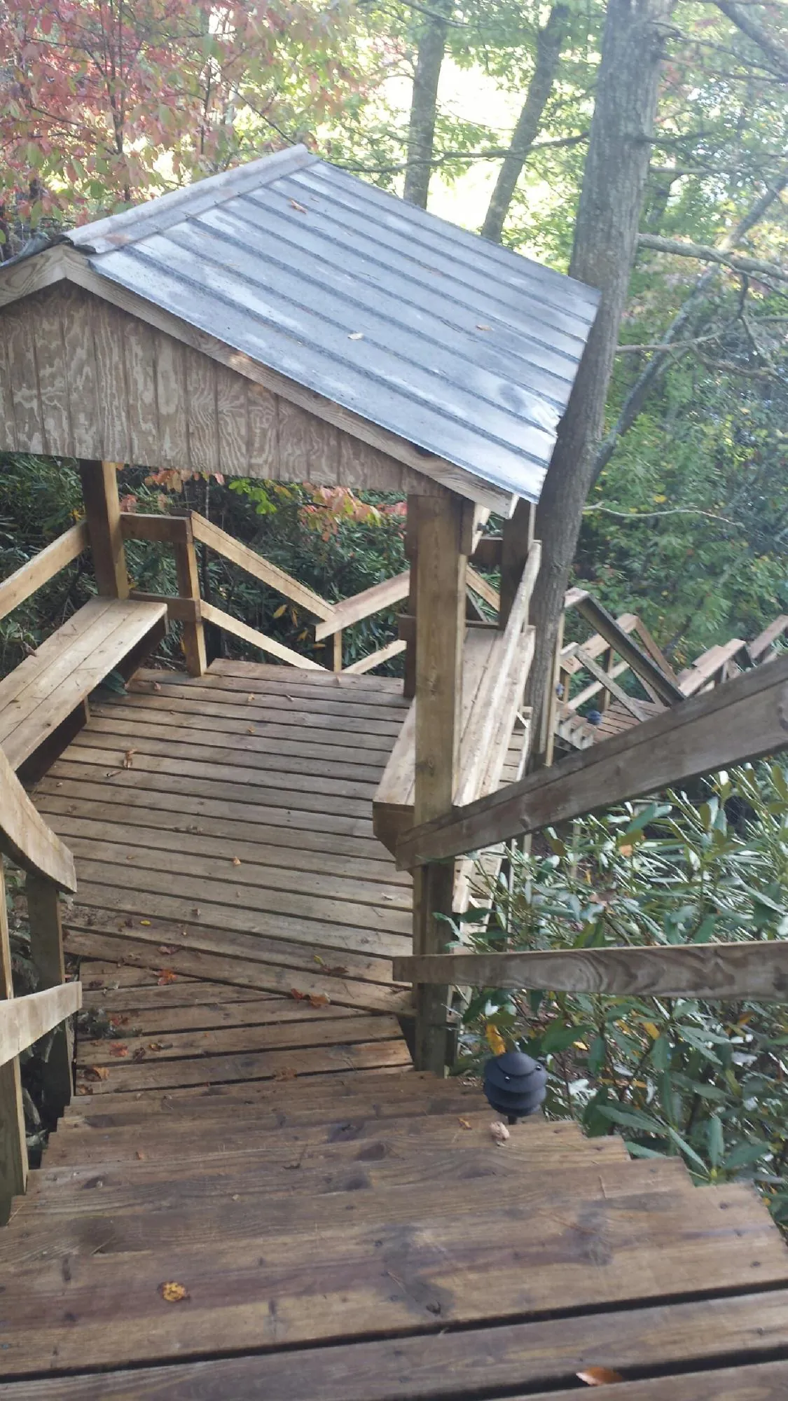 Metal roofed shelter over wooden steps on a wooded walkway — Skylight Repair & Installation work by our crew in Plaistow