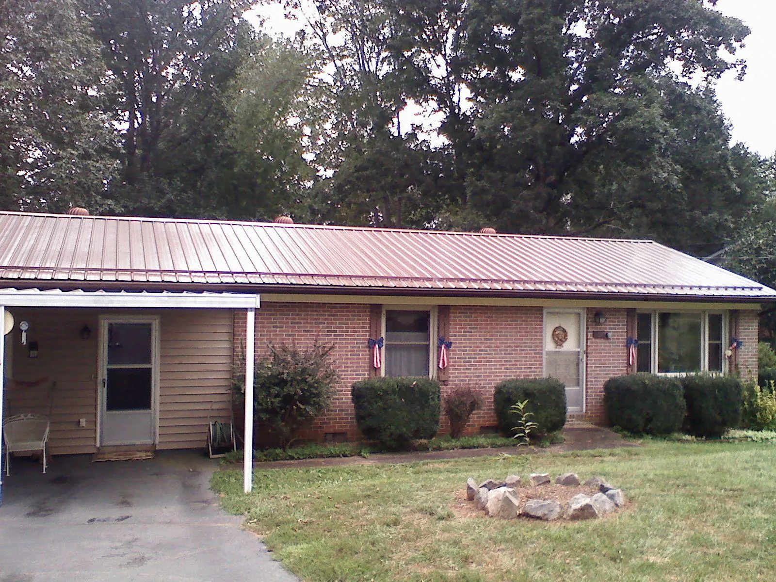 Bronze metal roof and carport on a brick ranch home — Roof Repair work by our crew in Plaistow